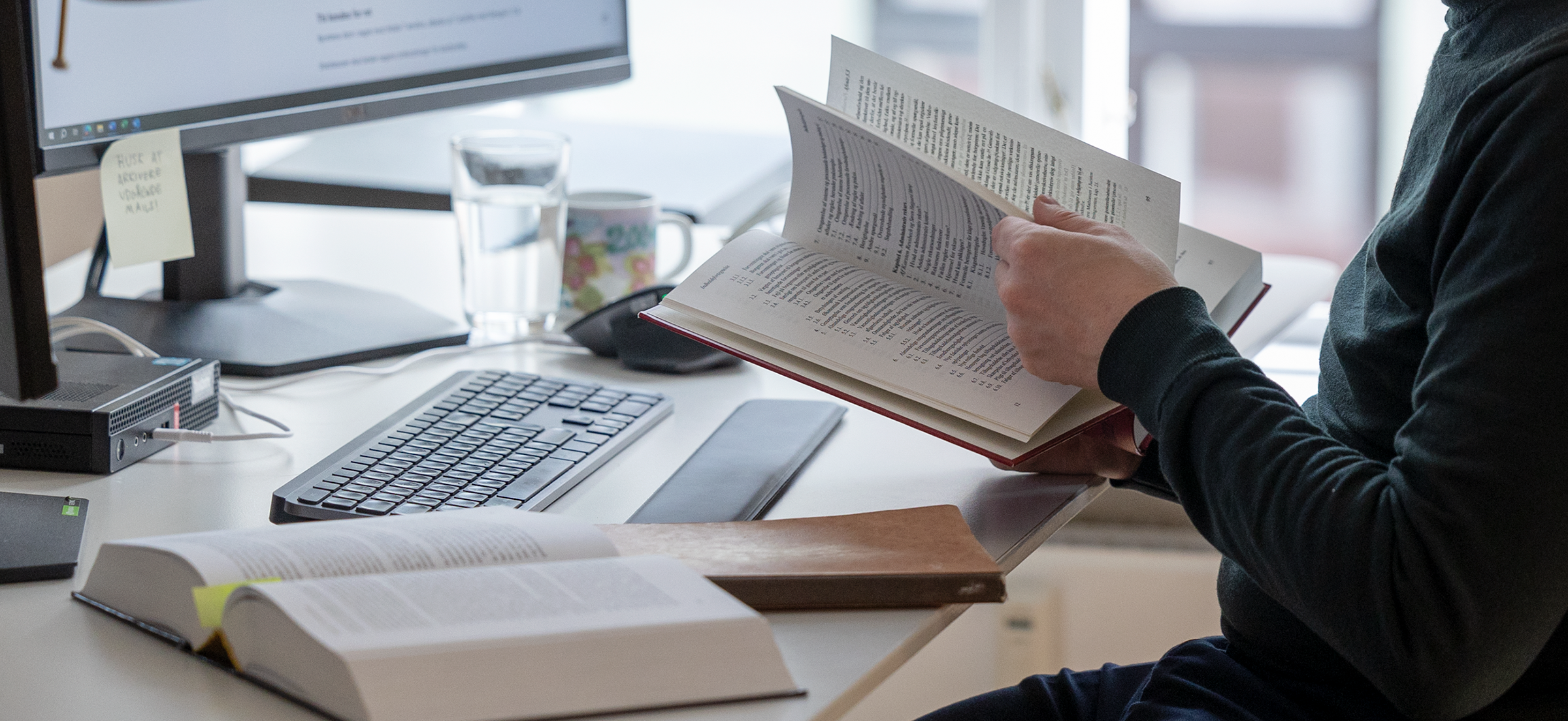 Wandall law employee researching with both books and computer screens with data